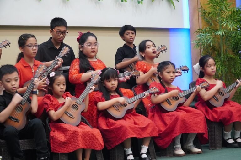Children in red playing ukuleles at a church program